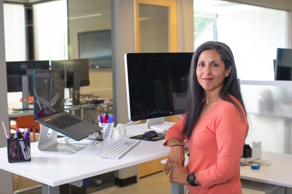 Woman at a standing desk in a modern office, representing small business cash flow management