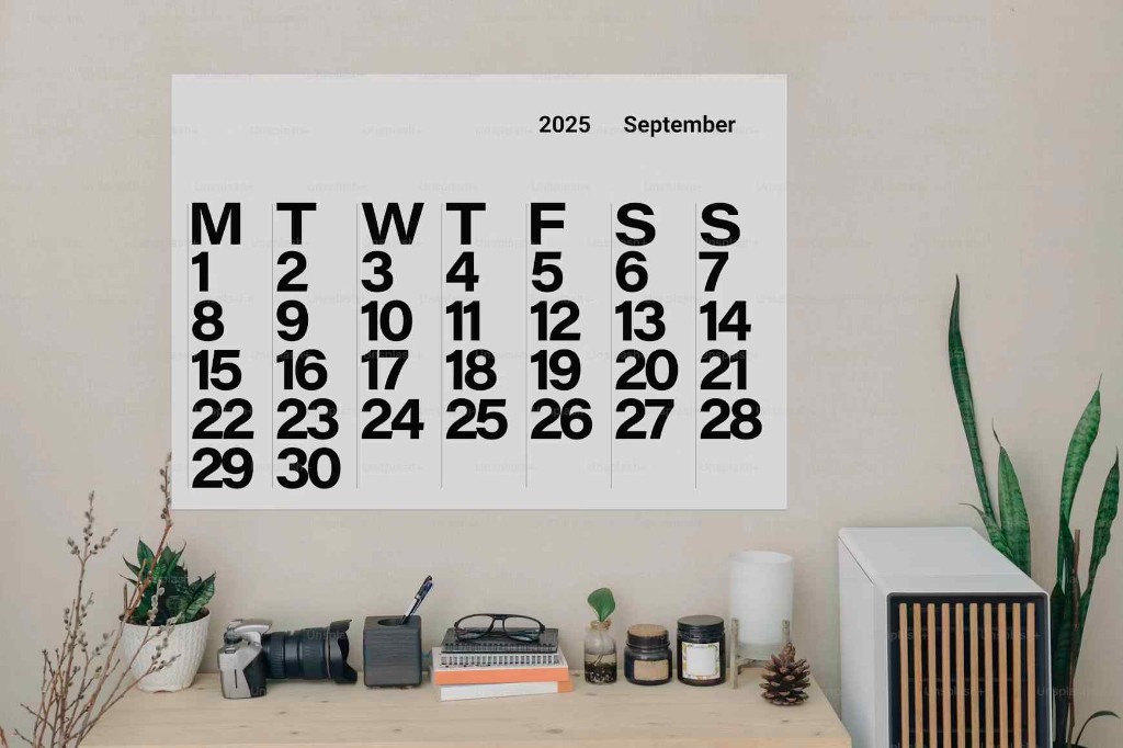 Wall calendar showing September 2025 above a desk, symbolizing scheduled recurring billing